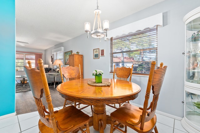 dining room with a notable chandelier, light wood-type flooring, and a textured ceiling