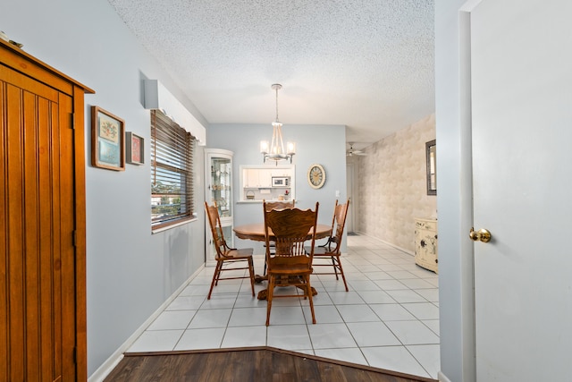 dining space featuring a textured ceiling, light wood-type flooring, and a notable chandelier