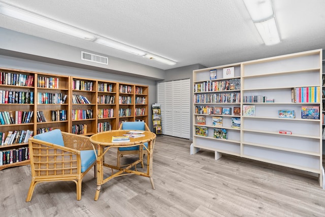 living area with a textured ceiling and hardwood / wood-style flooring