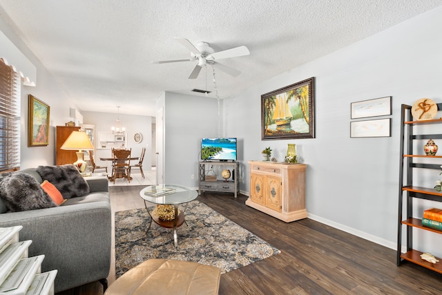 living room with dark hardwood / wood-style floors, ceiling fan, and a textured ceiling