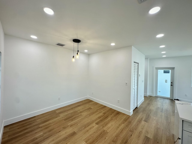 unfurnished room with light wood-type flooring, baseboards, and recessed lighting