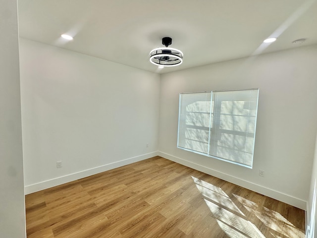 spare room with light wood-style floors, baseboards, and recessed lighting