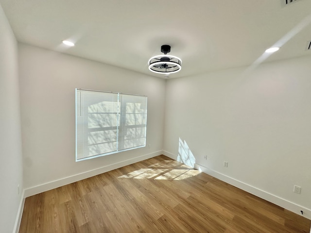 unfurnished room featuring light wood-style flooring, baseboards, and recessed lighting