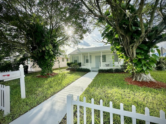 view of front of home featuring covered porch, a front lawn, and a fenced front yard