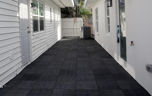 view of patio featuring central air condition unit and fence