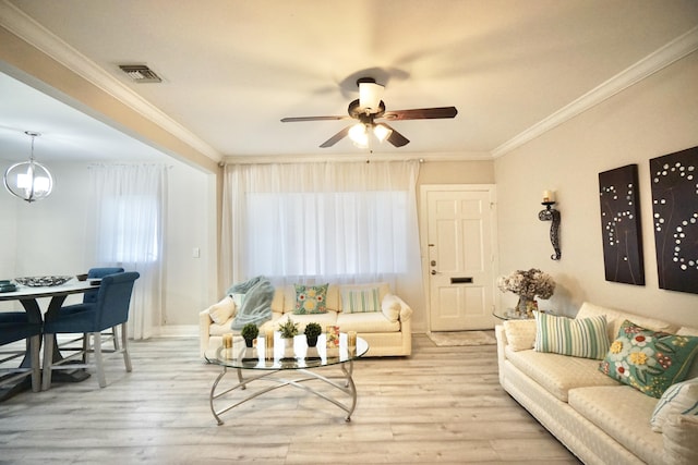 living area featuring a wealth of natural light, crown molding, and wood finished floors