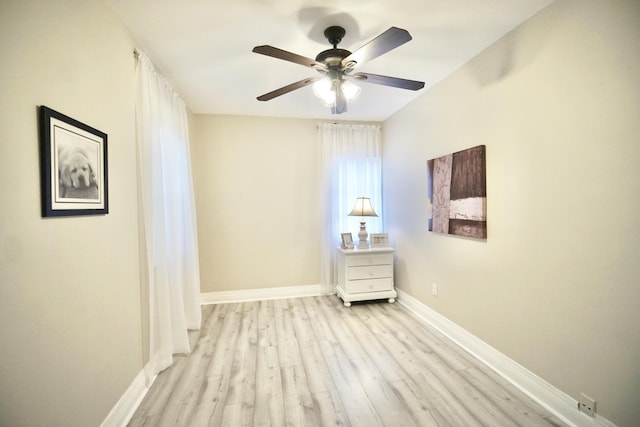 spare room with a ceiling fan, baseboards, and wood finished floors