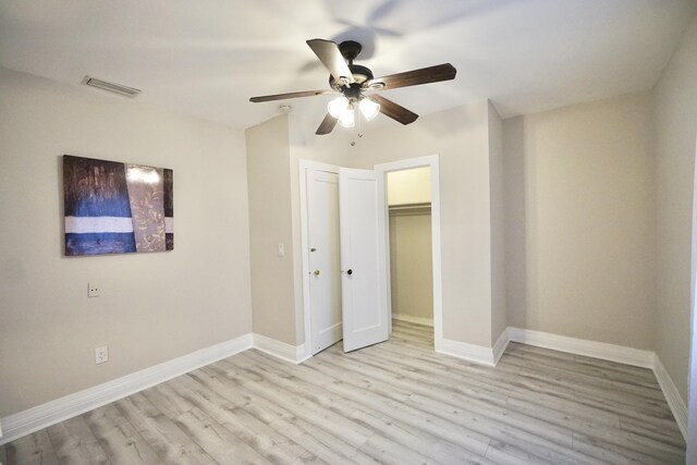 unfurnished bedroom featuring baseboards, visible vents, and light wood finished floors