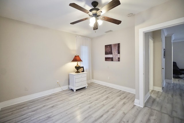 interior space with baseboards, visible vents, ceiling fan, and light wood finished floors