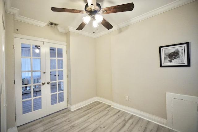 spare room with visible vents, baseboards, light wood-style flooring, ornamental molding, and french doors