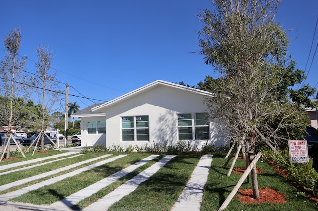 view of front of property with a front yard and stucco siding