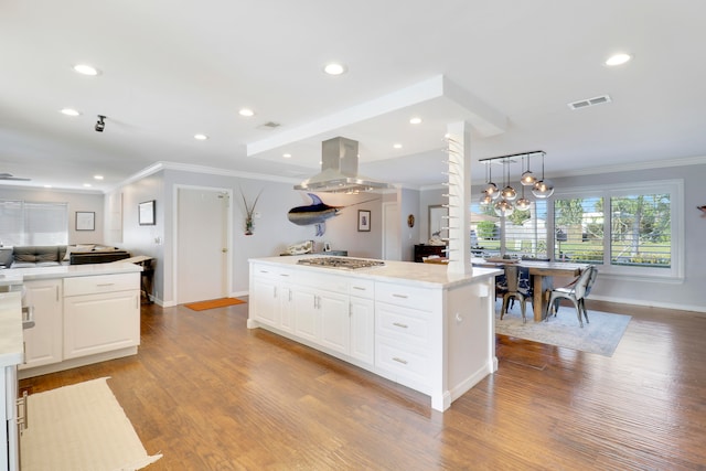 kitchen featuring a center island, island exhaust hood, decorative light fixtures, white cabinets, and light wood-type flooring