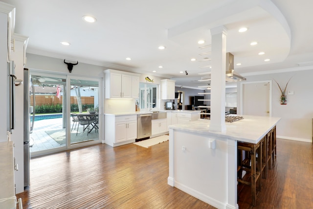 kitchen featuring hardwood / wood-style floors, dishwasher, white cabinetry, and a breakfast bar