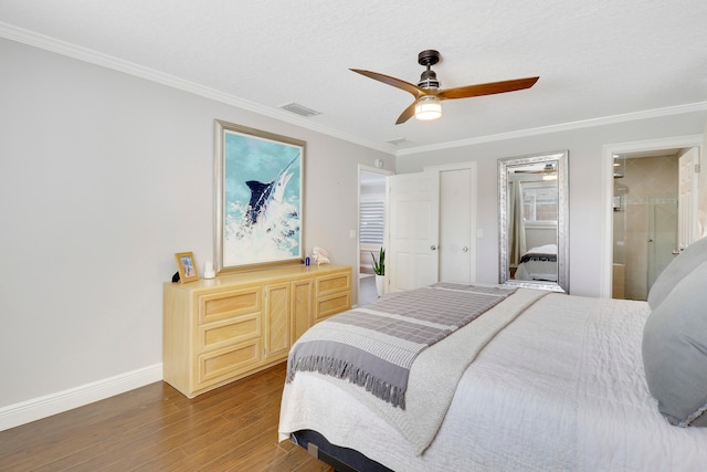 bedroom featuring ceiling fan, crown molding, dark wood-type flooring, and connected bathroom