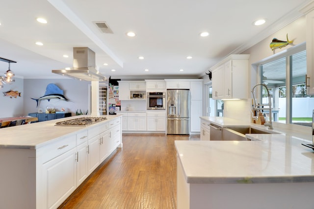 kitchen with island exhaust hood, appliances with stainless steel finishes, white cabinets, and sink