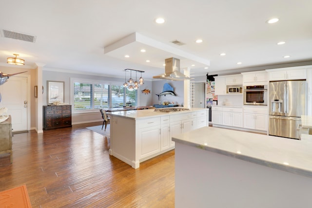 kitchen with white cabinetry, appliances with stainless steel finishes, pendant lighting, a kitchen island, and hardwood / wood-style flooring