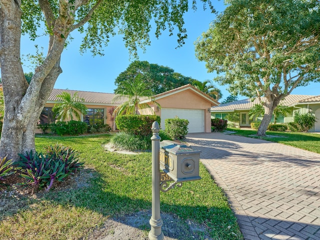 ranch-style house featuring a garage and a front yard