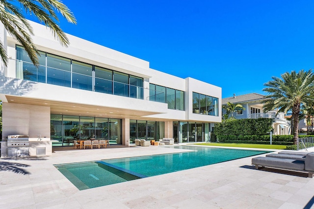 view of pool featuring area for grilling and a patio