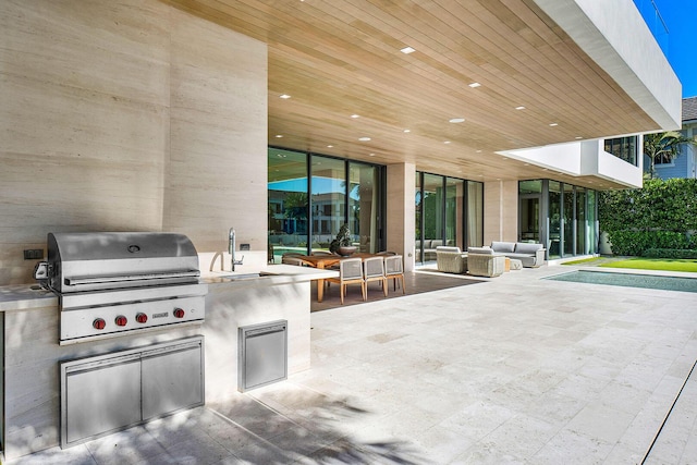 view of patio featuring an outdoor living space, sink, exterior kitchen, and a grill