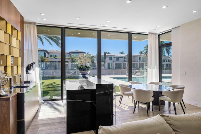 dining room featuring a wall of windows and light wood-type flooring