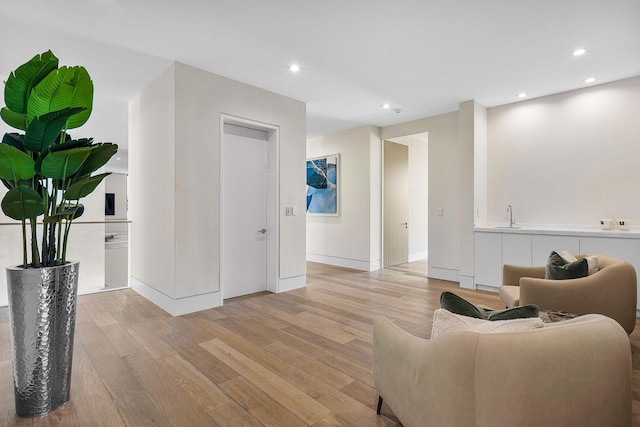 living room with light wood-type flooring and sink