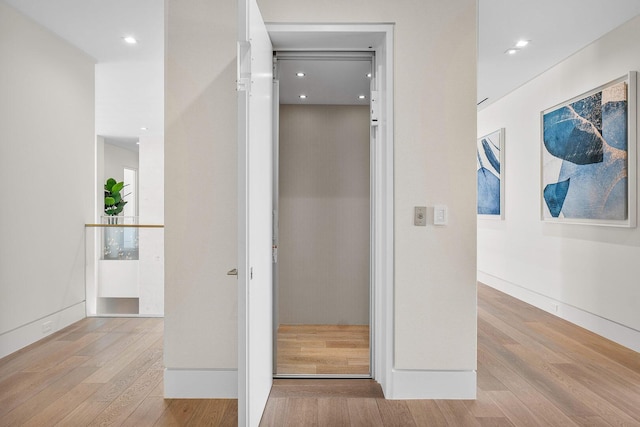 interior space with elevator and light wood-type flooring