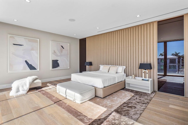 bedroom with wood-type flooring and access to outside