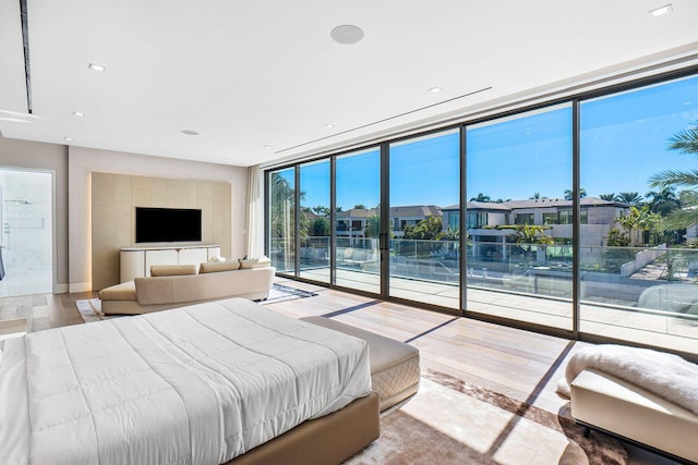 bedroom with hardwood / wood-style flooring and floor to ceiling windows