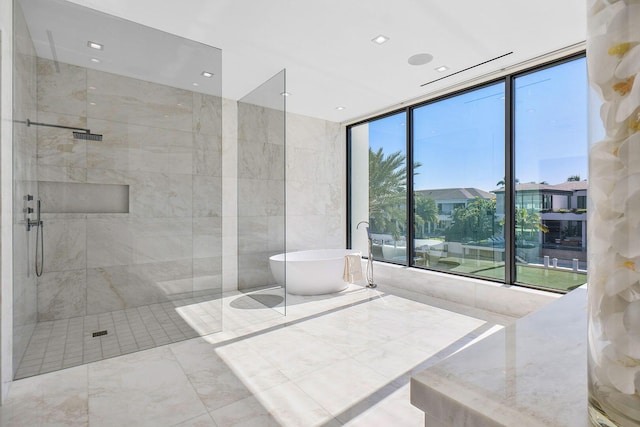 bathroom featuring independent shower and bath, tile walls, and a wall of windows