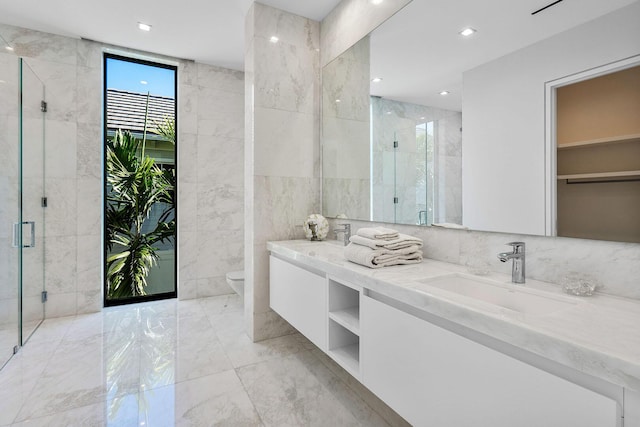 bathroom featuring walk in shower, vanity, toilet, and tile walls