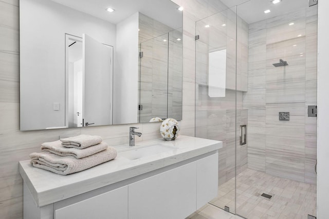 bathroom with vanity and a shower with door