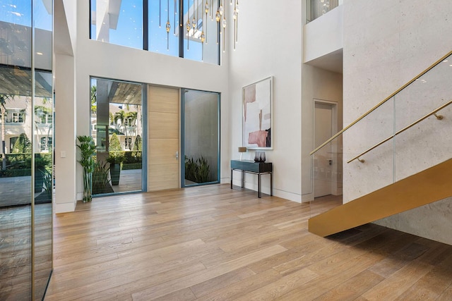 foyer with a towering ceiling and light hardwood / wood-style floors