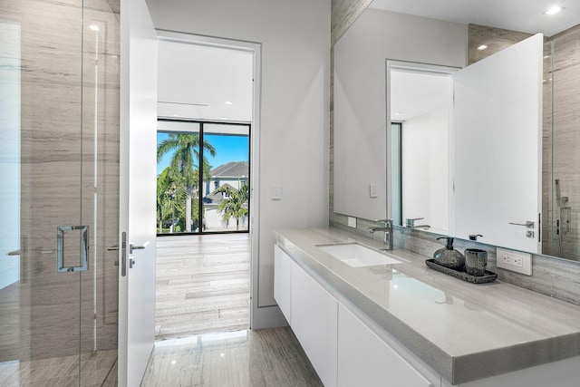 bathroom with hardwood / wood-style flooring, vanity, and walk in shower