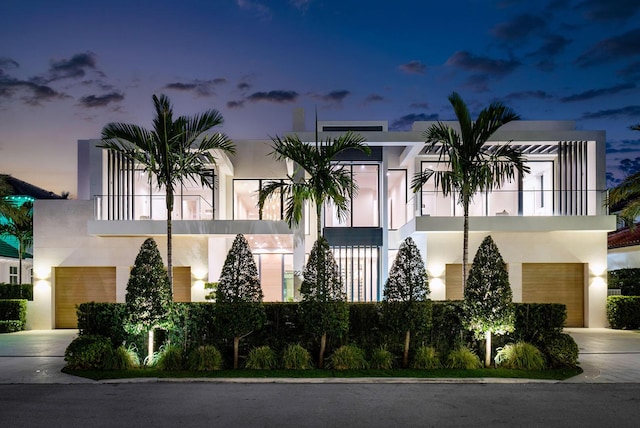 view of front facade featuring a garage and a balcony