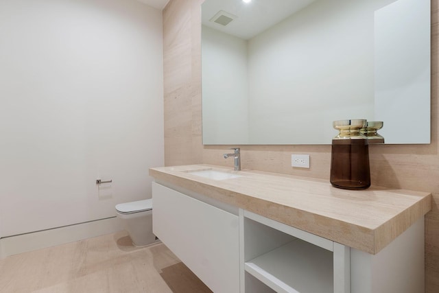 bathroom featuring hardwood / wood-style floors, vanity, and toilet