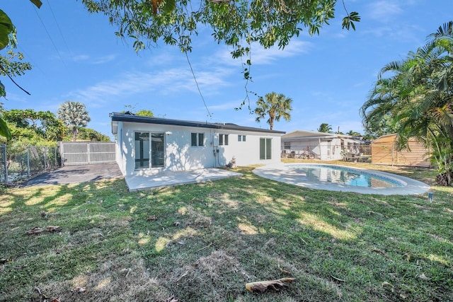 back of property with a fenced in pool, stucco siding, a yard, a fenced backyard, and a patio area