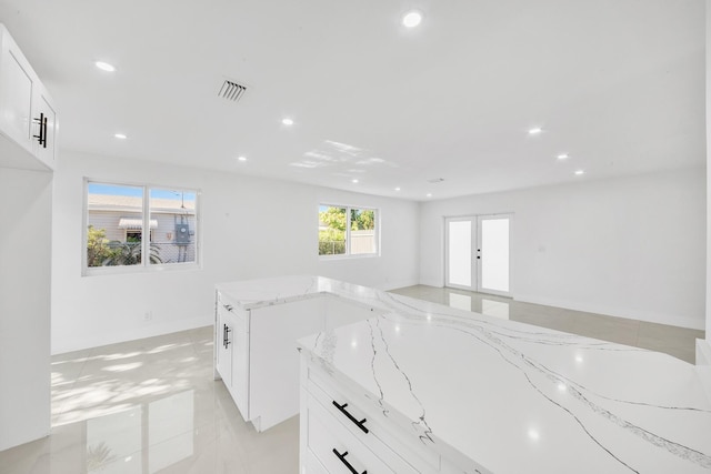 kitchen with light stone countertops, visible vents, recessed lighting, white cabinets, and french doors