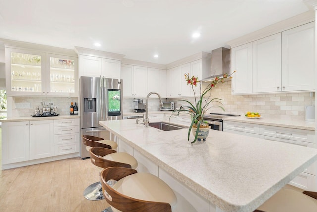 11282 Glen Oaks Ct Unit 31-C, North Palm Beach, FL 33408 - kitchen featuring stainless steel refrigerator with ice dispenser, backsplash, a kitchen breakfast bar, an island with sink, and white cabinets