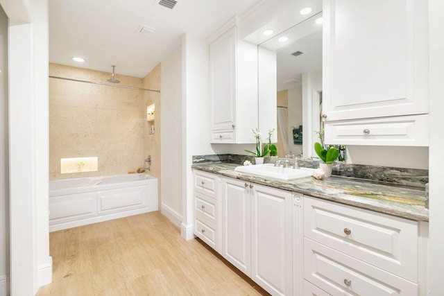 bathroom with wood-type flooring, vanity, and shower with separate bathtub