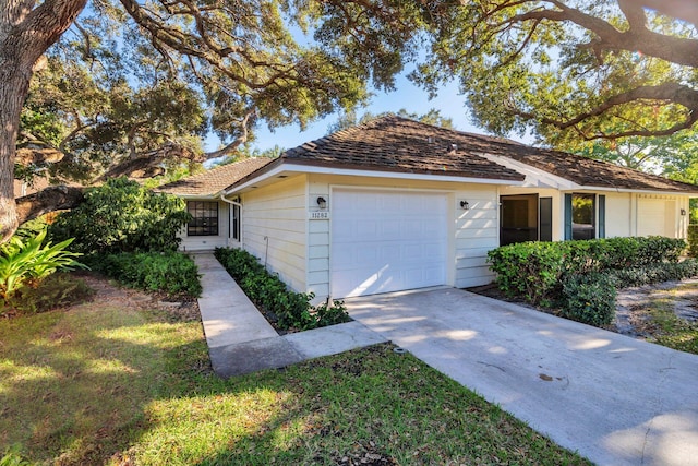 single story home with a garage and a front lawn