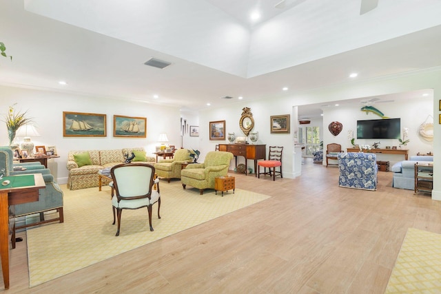 living room with crown molding and light wood-type flooring