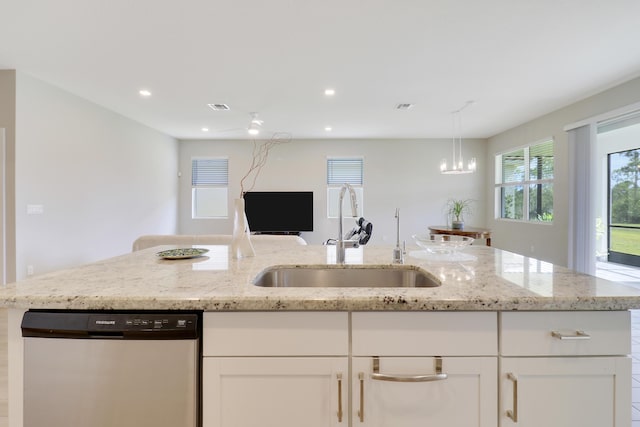 kitchen featuring white cabinets, light stone counters, stainless steel dishwasher, and sink