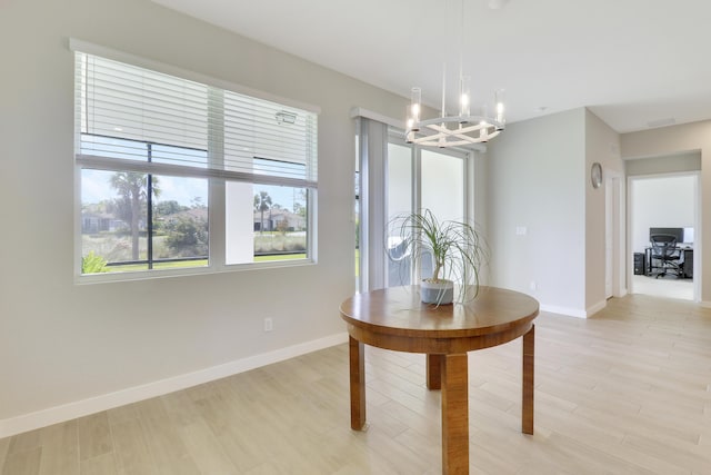 dining area with a chandelier and light hardwood / wood-style flooring