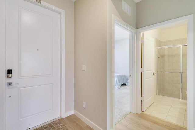 hallway with light hardwood / wood-style floors