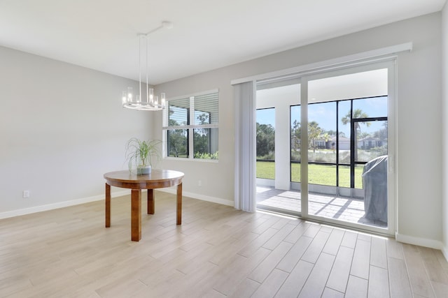 unfurnished dining area featuring light wood-type flooring and a notable chandelier