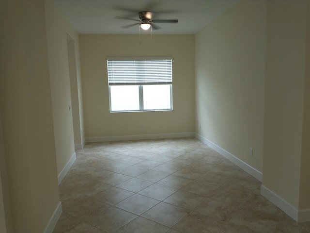 tiled spare room featuring ceiling fan