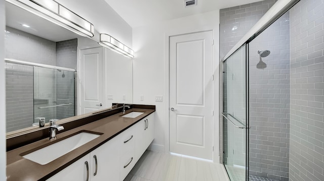 bathroom with tile patterned floors, vanity, and an enclosed shower