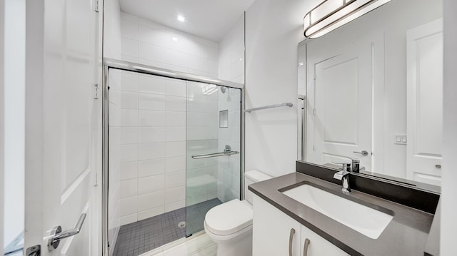 bathroom with vanity, toilet, and a shower with shower door