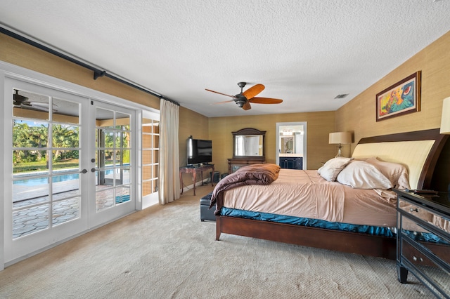 carpeted bedroom featuring french doors, a textured ceiling, access to outside, and ceiling fan