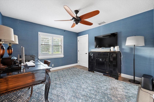 home office with a textured ceiling and ceiling fan